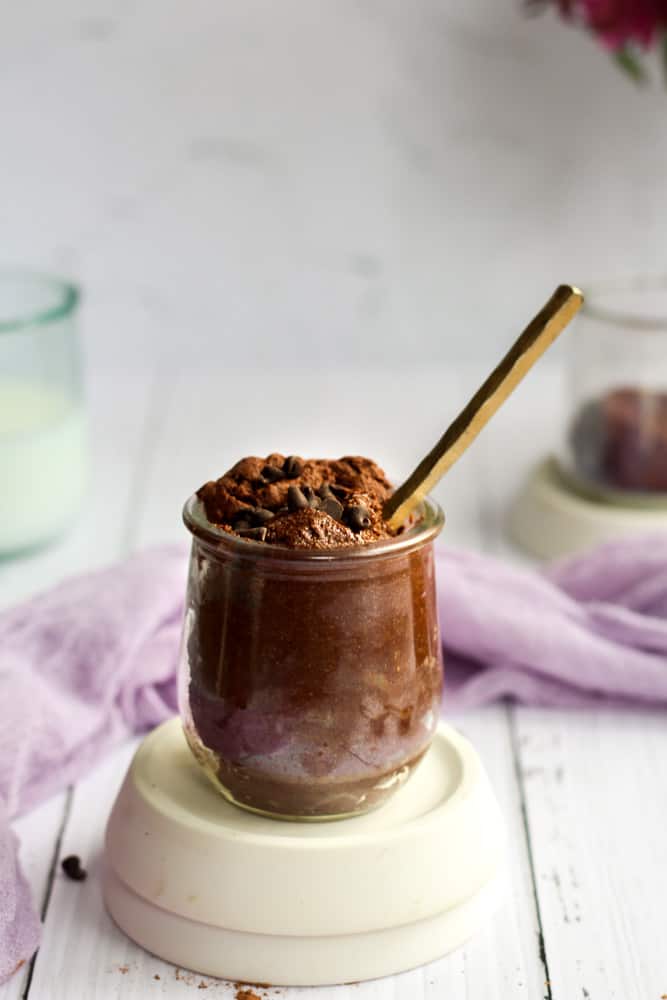 edible brownie batter in a glass jar with a gold spoon.