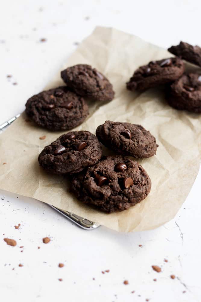 eggless chocolate cookies on brown parchment paper on cooling rack.