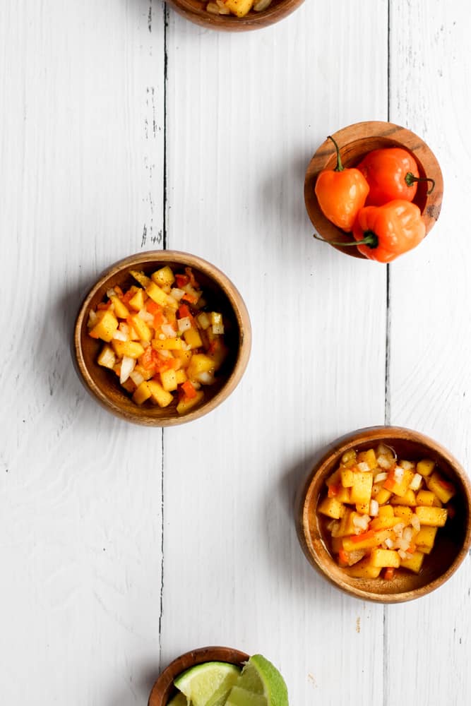 5 wood bowls filled with various ingredients that make up spicy mango salsa.