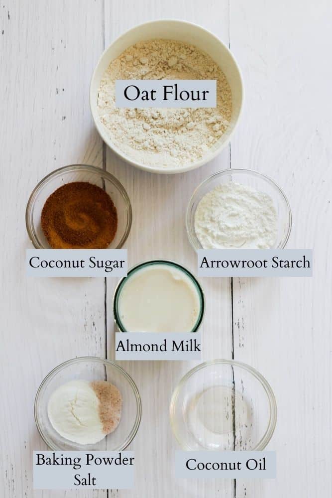ingredients for oat flour pancakes on a white backdrop labeled with black text.
