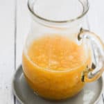 sugar free peach compote in a small glass pitcher.