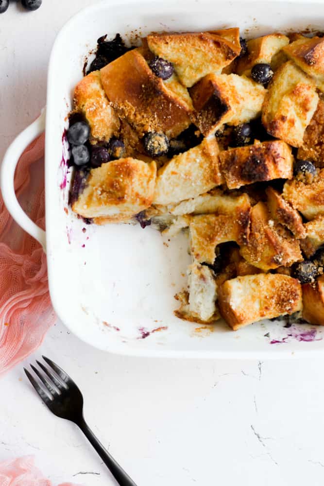 healthy French toast bake in a white baking dish with a piece cut out.