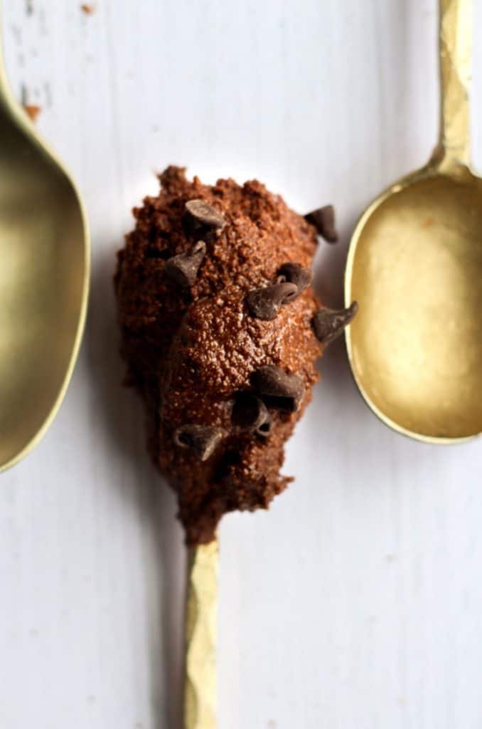 edible brownie batter on a gold spoon.