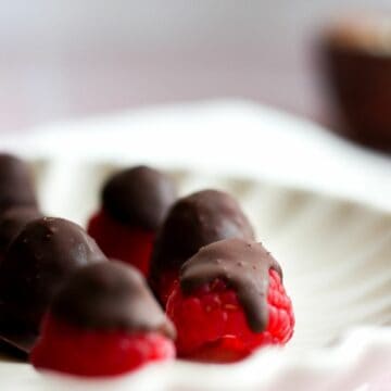 chocolate covered raspberries on a white plate.
