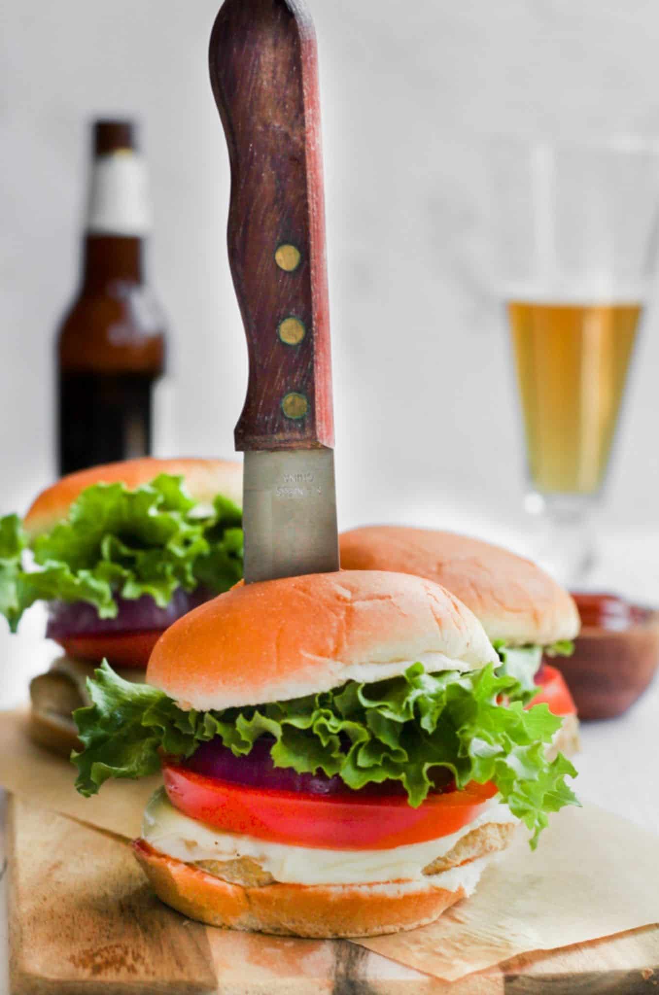 air fryer turkey burger on a bun with a knife stabbing into it.