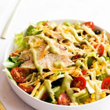 spicy southwest salad with a green dressing in a white bowl.