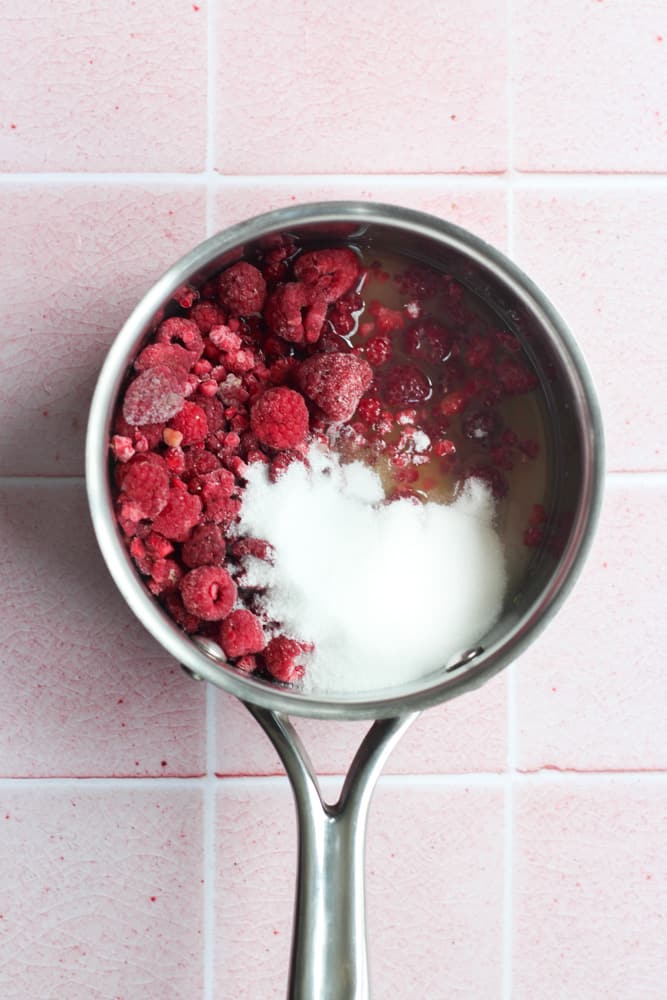 sugar free raspberry compote ingredients in a silver pot.