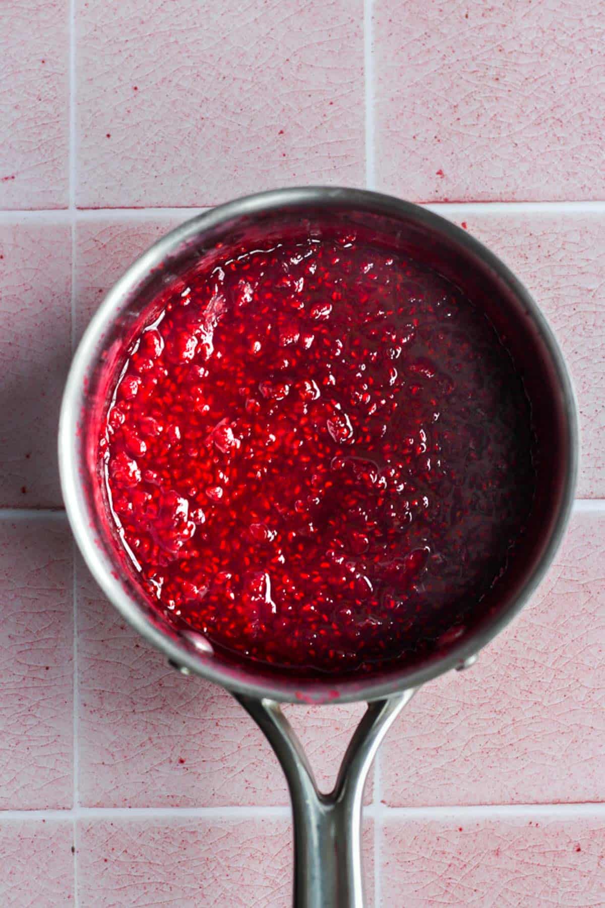 healthy raspberry compote in a silver pot.