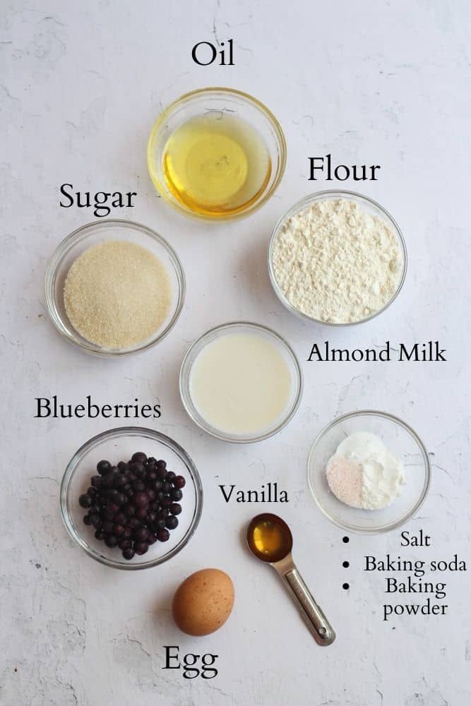 ingredients for dairy free muffins on a white backdrop labeled with black text.