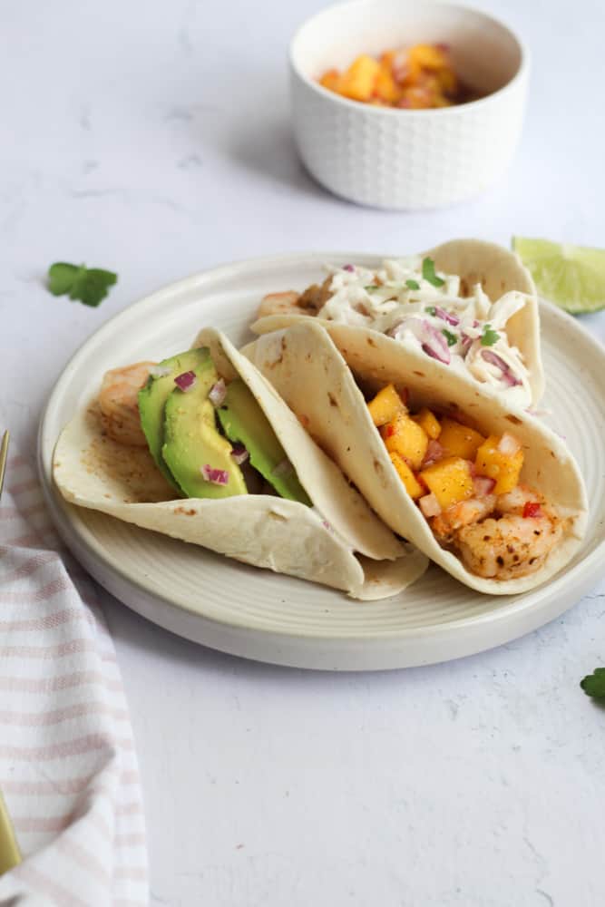 easy air fryer shrimp tacos on a white plate.
