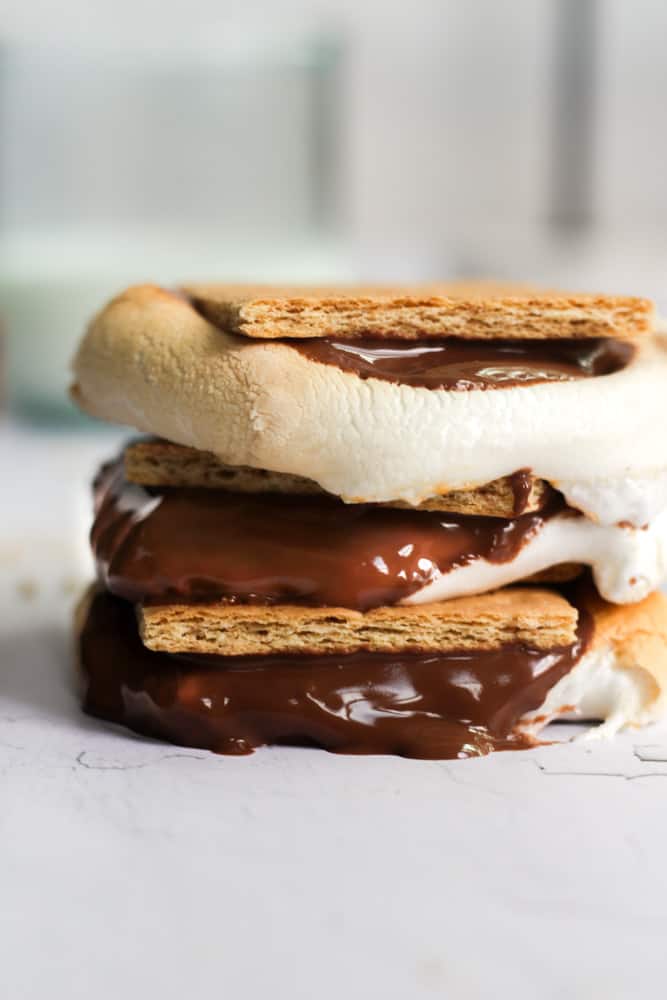 s'mores made in the air fryer stacked on top of each other on parchment paper.