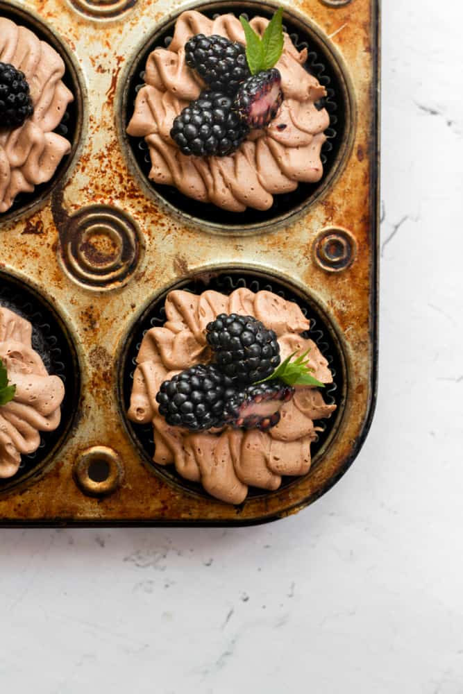 healthy chocolate cupcakes without eggs topped with chocolate buttercream and blackberries.