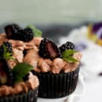 eggless chocolate cupcakes topped with blackberries and chocolate frosting.