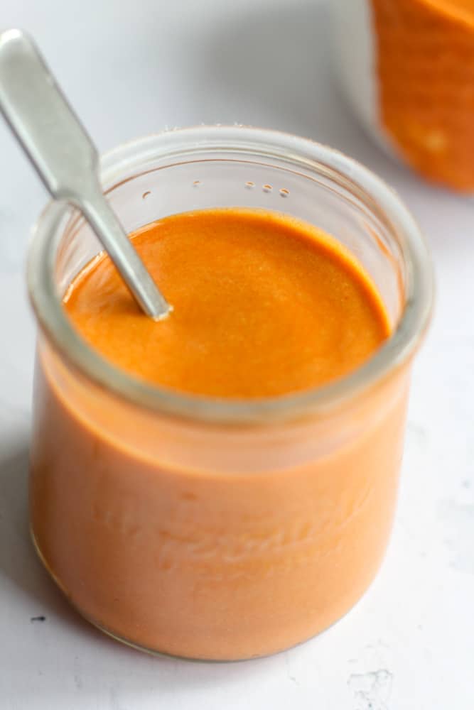 healthy hot sauce in a jar with a silver spoon.