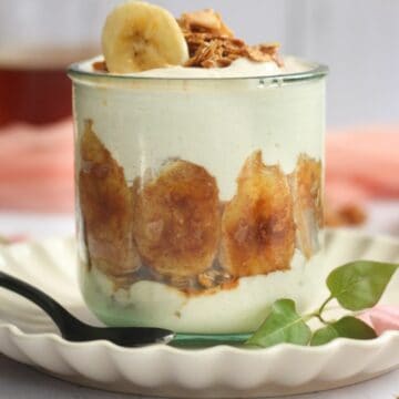 air fryer bananas in a glass jar with yogurt and granola.