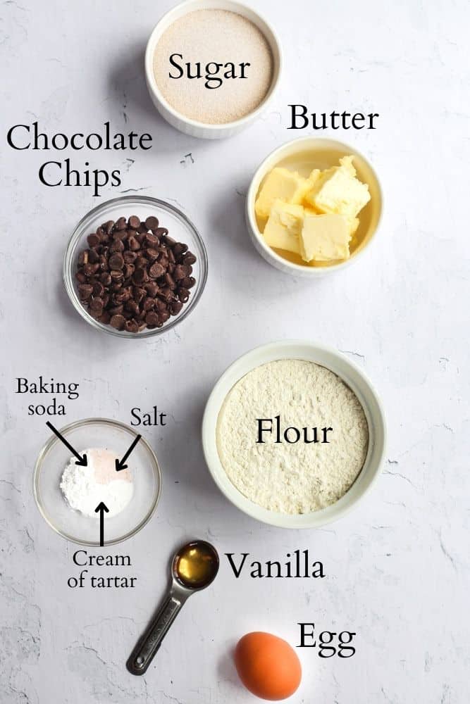 ingredients for chocolate chip cookies without brown sugar labeled on a white backdrop.