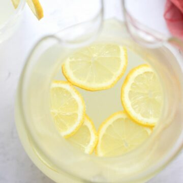 sugar free lemonade in a glass pitcher with lemon slices.