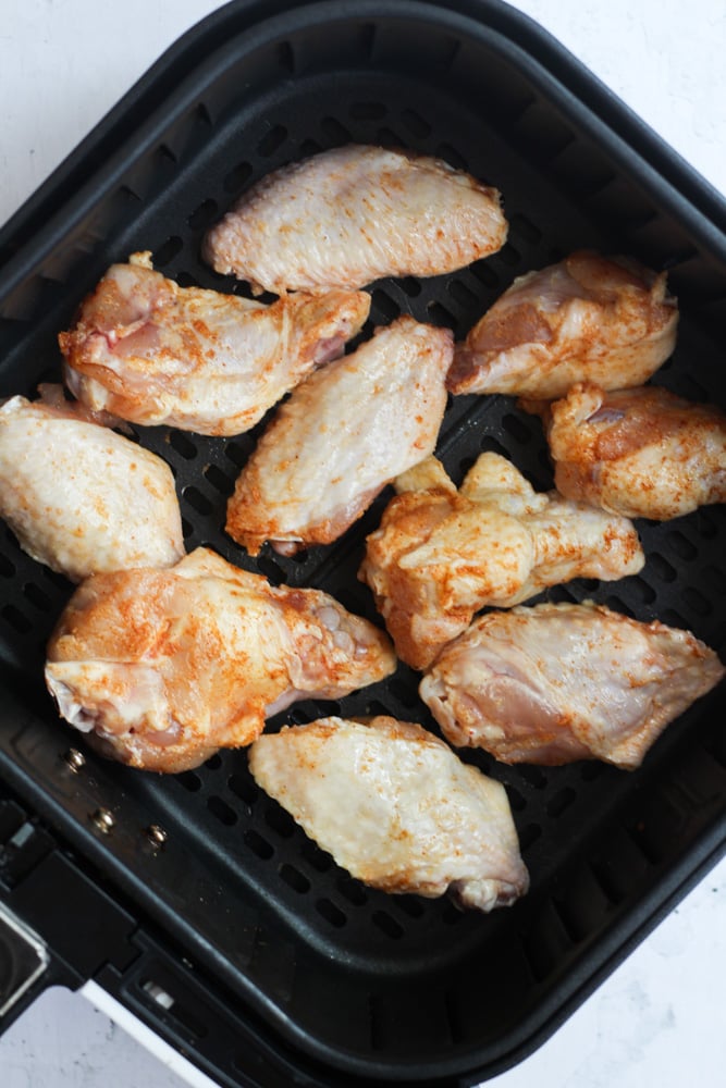 healthy chicken wings in air fryer basket.