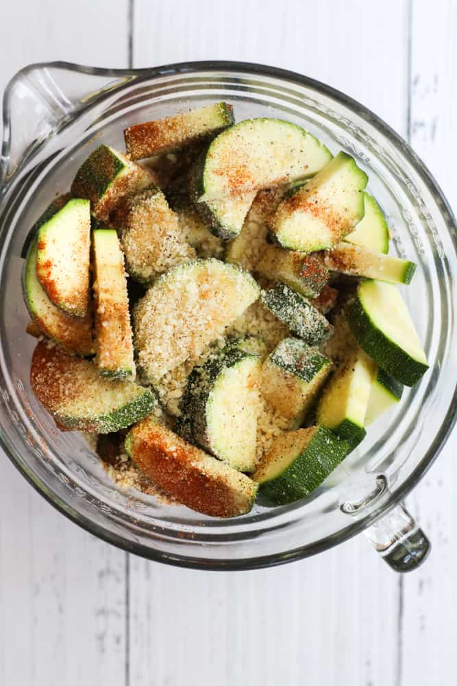 zucchini slices in a clear bowl with spices.
