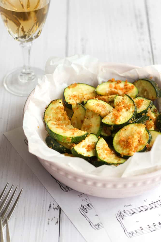 air fryer zucchini with a gluten free bread crumb in a pink bowl.
