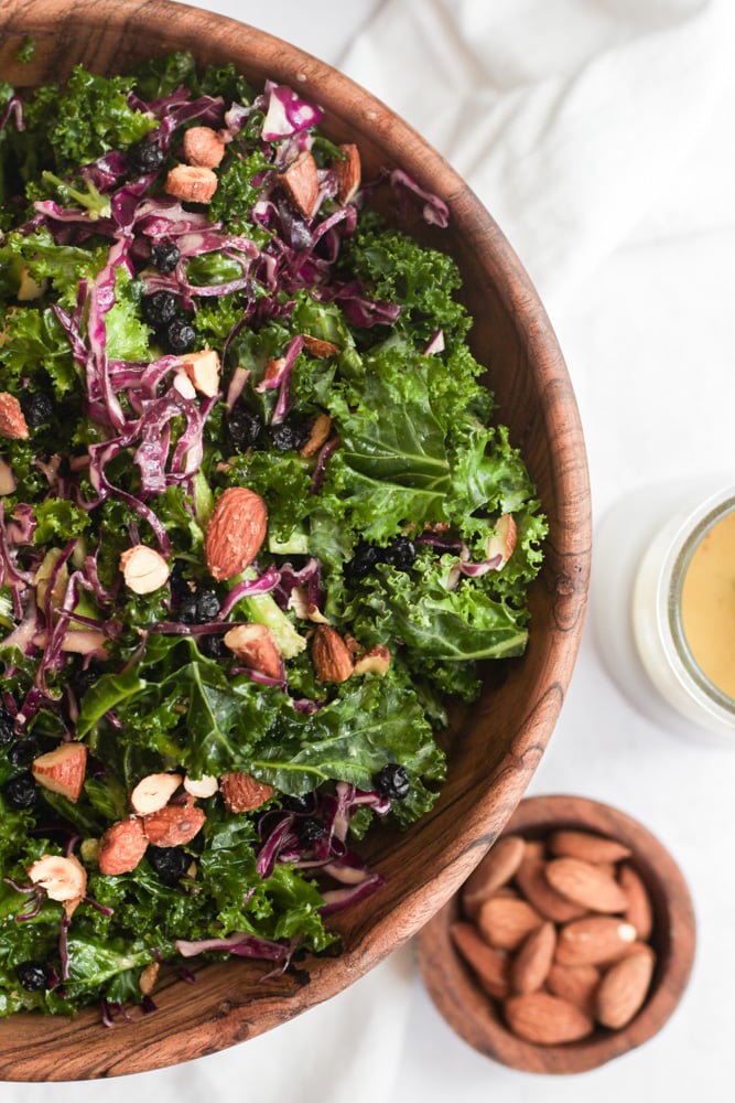 kale superfood salad topped with chopped almonds.