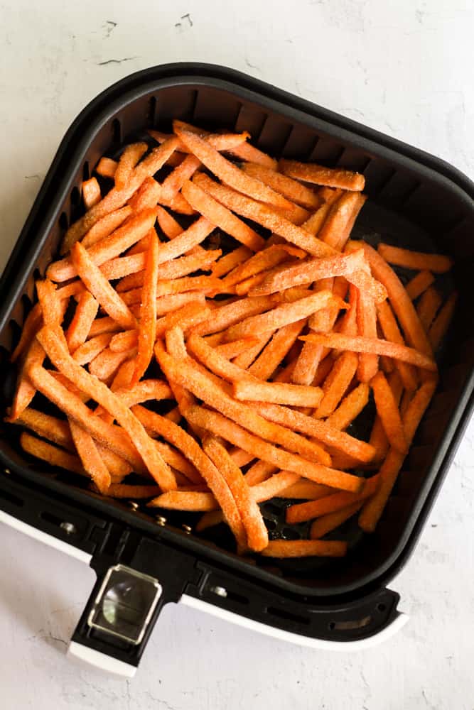 frozen fries in air fryer basket.