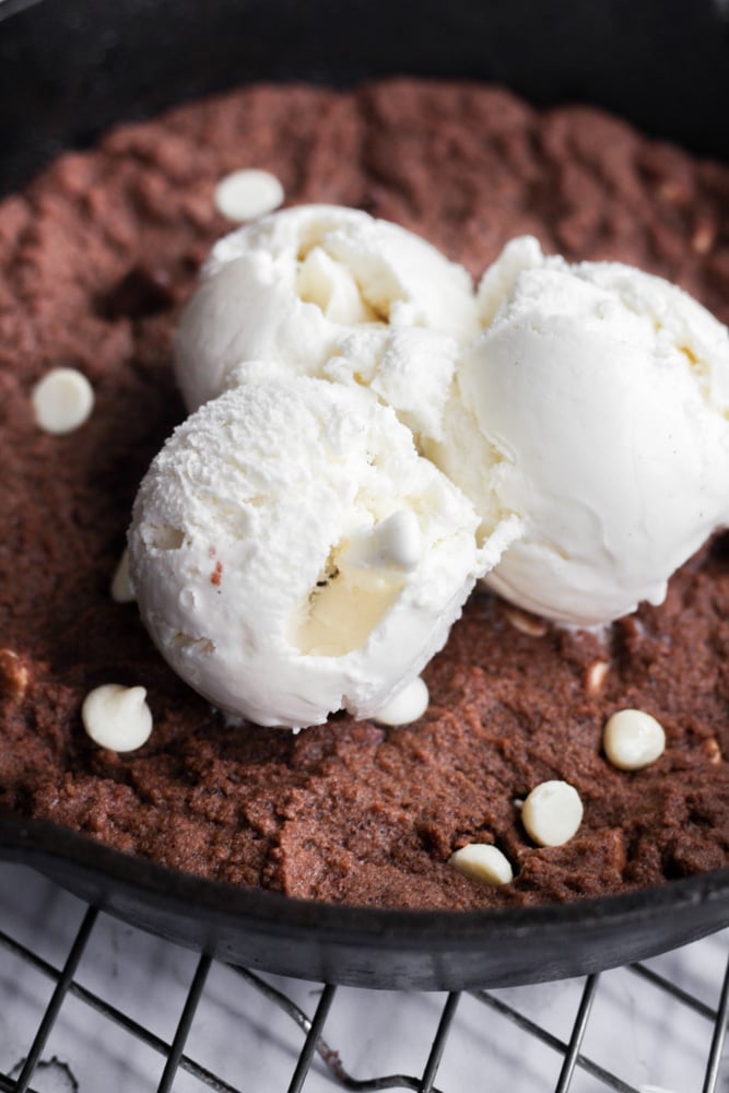 three vanilla ice cream scoops on a chocolate cookie.