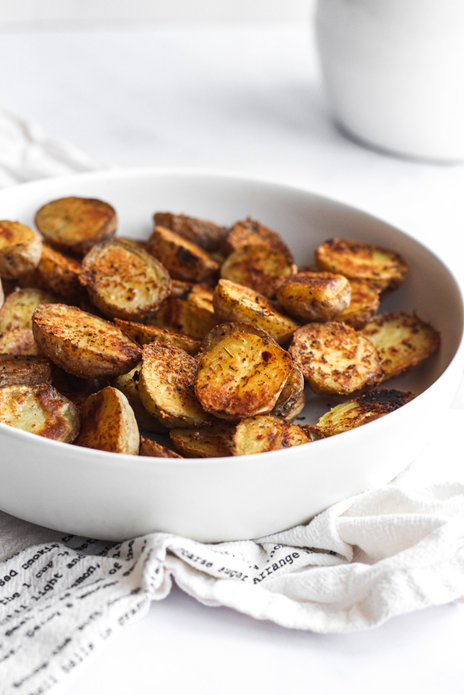 crispy potatoes in a white bowl to serve with chicken marsala.