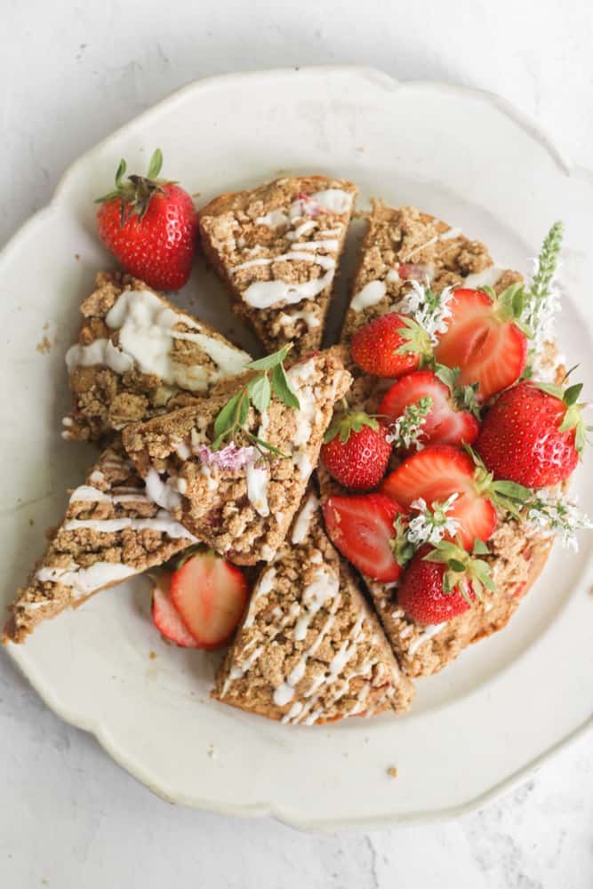 healthy banana crumb cake with strawberries cut into pieces on a white plate.