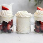 sugar free whipped cream in three glass jars, two with berries.
