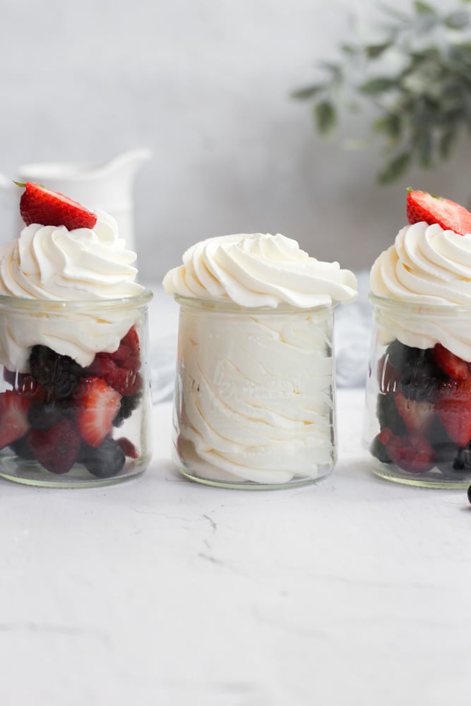 sugar free whipped cream in three glass jars, two with berries.