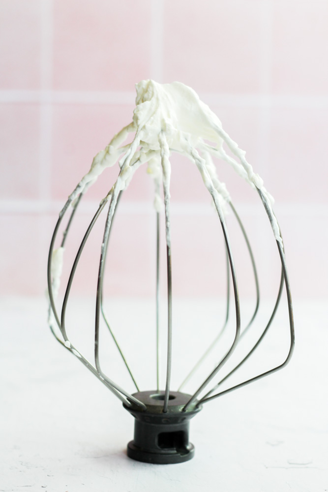 sugar free whipped cream with stiff peaks on a mixer whisk attachment.