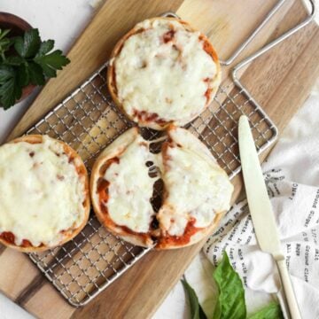 english muffin pizzas made in the air fryer on a wire cooling rack.