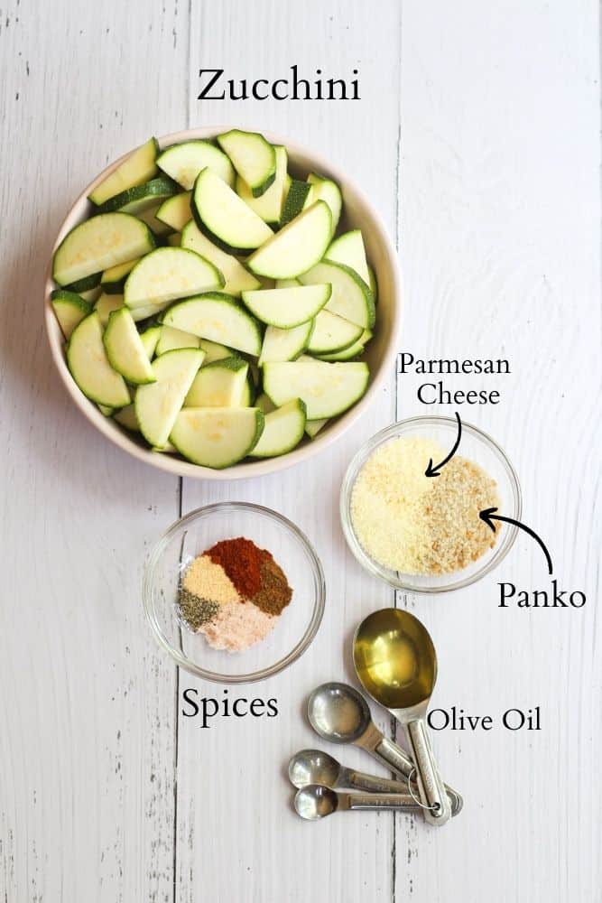 ingredients for healthy air fryer zucchini on a white backdrop with black text.