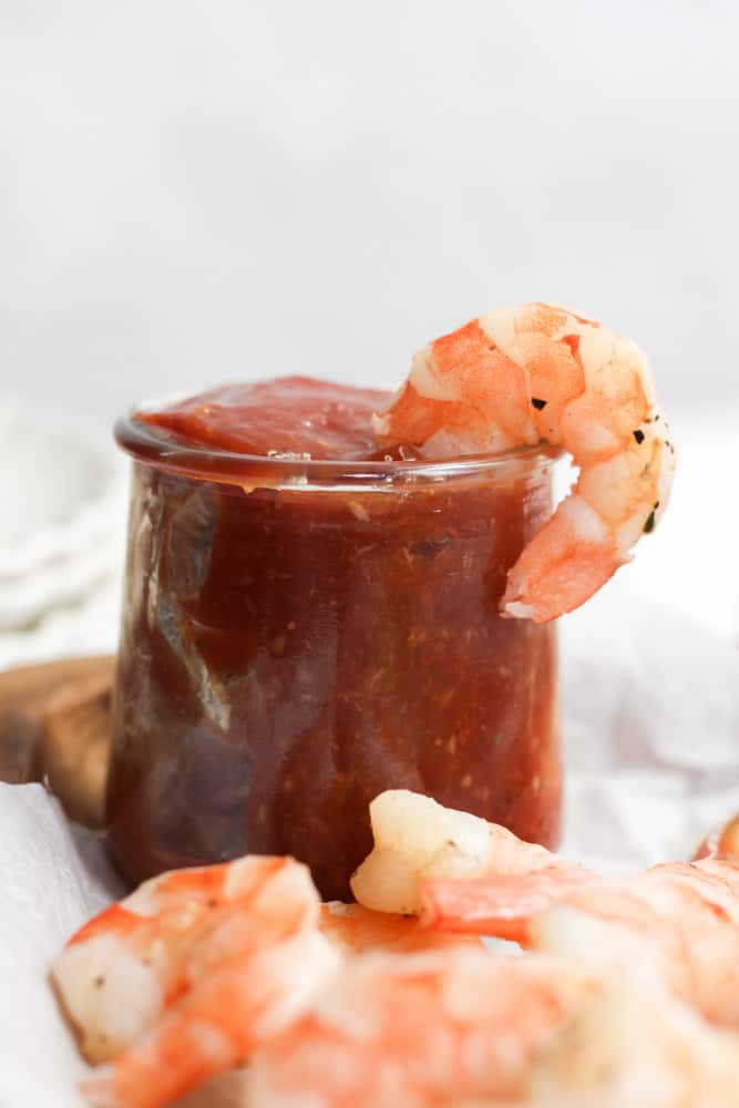 air fryer shrimp on the side of a jar of Cajun cocktail sauce.