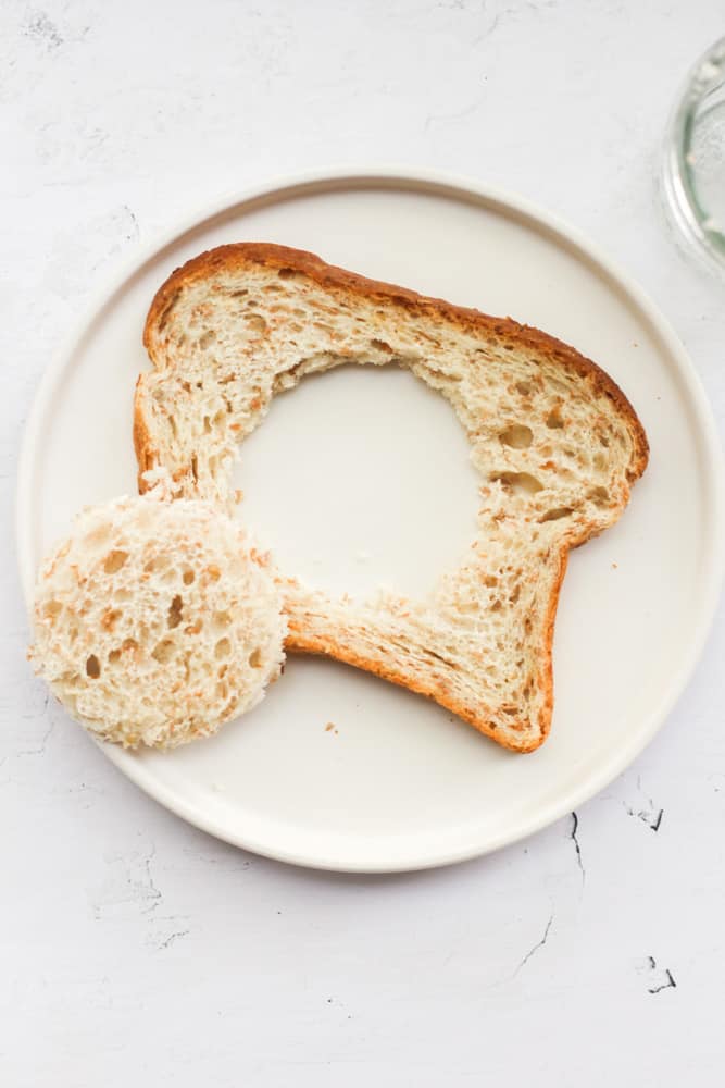 bread on a white plate with a hole cut in the center.