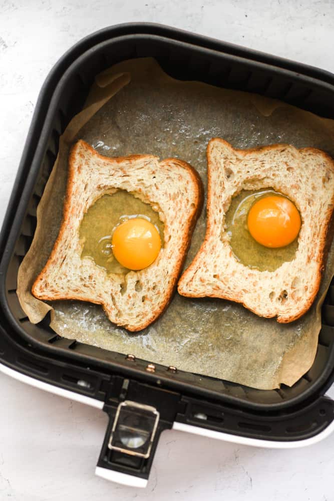 air fryer egg toasts in air fryer basket.
