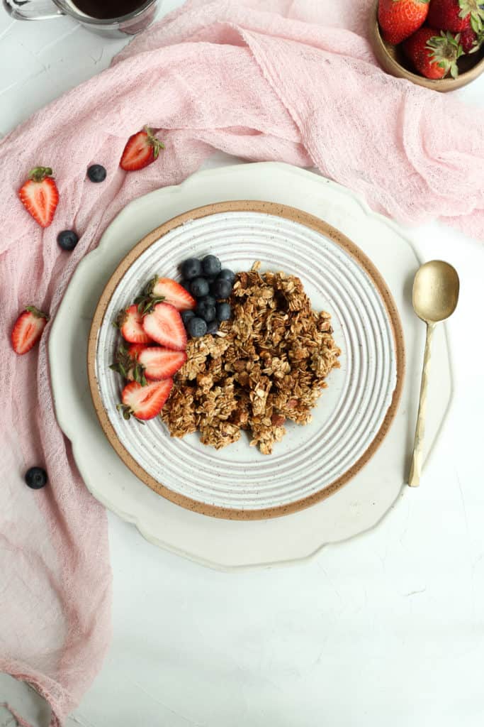 oil free granola in a gray bowl with fresh berries.