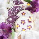 no spread sugar cookies decorated with flowers in a wood box.