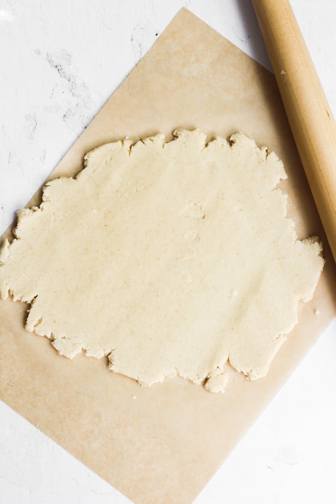 cut out cookie dough rolled on parchment paper.