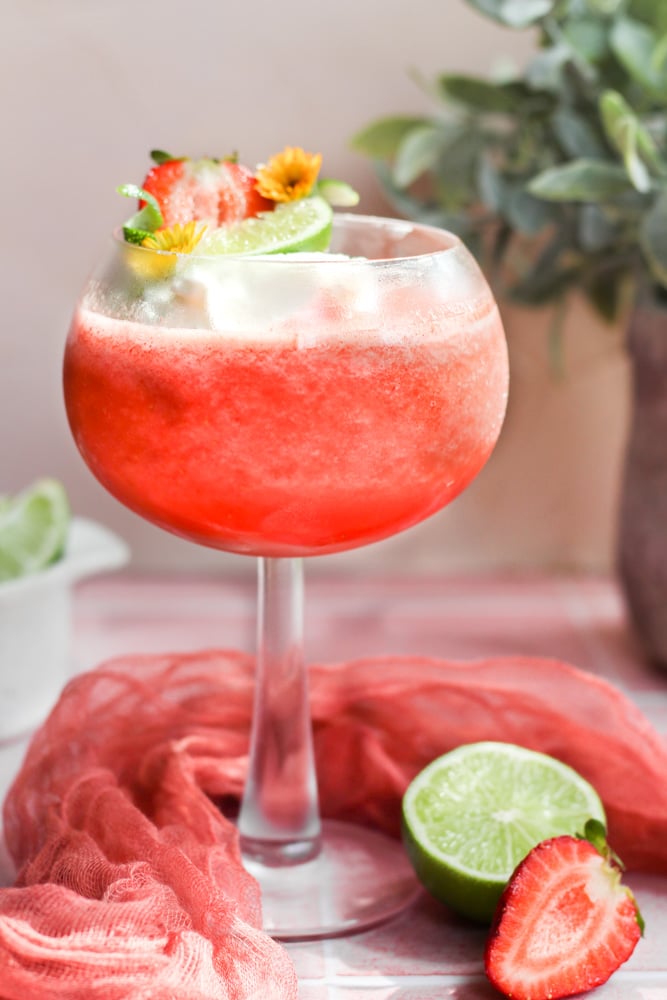 virgin strawberry daiquiri in a glass with lime wedge and strawberry.
