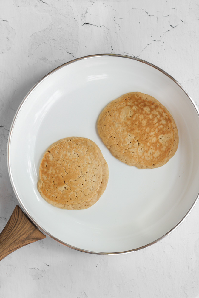 pancakes without sugar cooked in a white skillet.