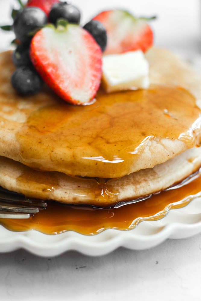 healthy pancakes without sugar on a white plate with syrup.