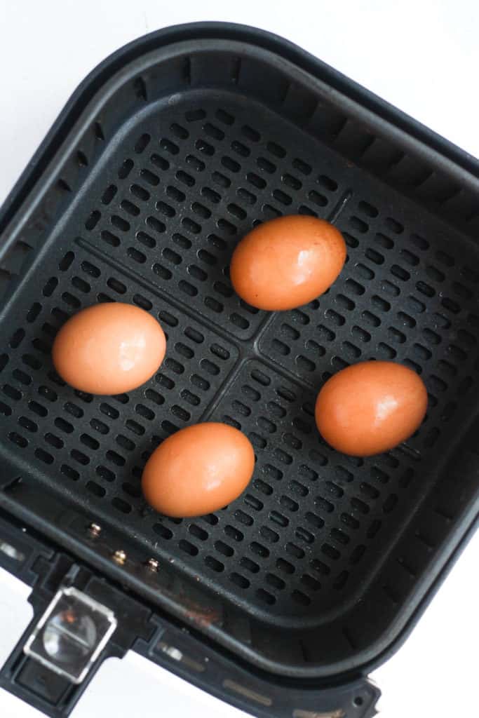 brown eggs in air fryer basket.