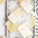 lemonade popsicles on a tray with ice cubes.