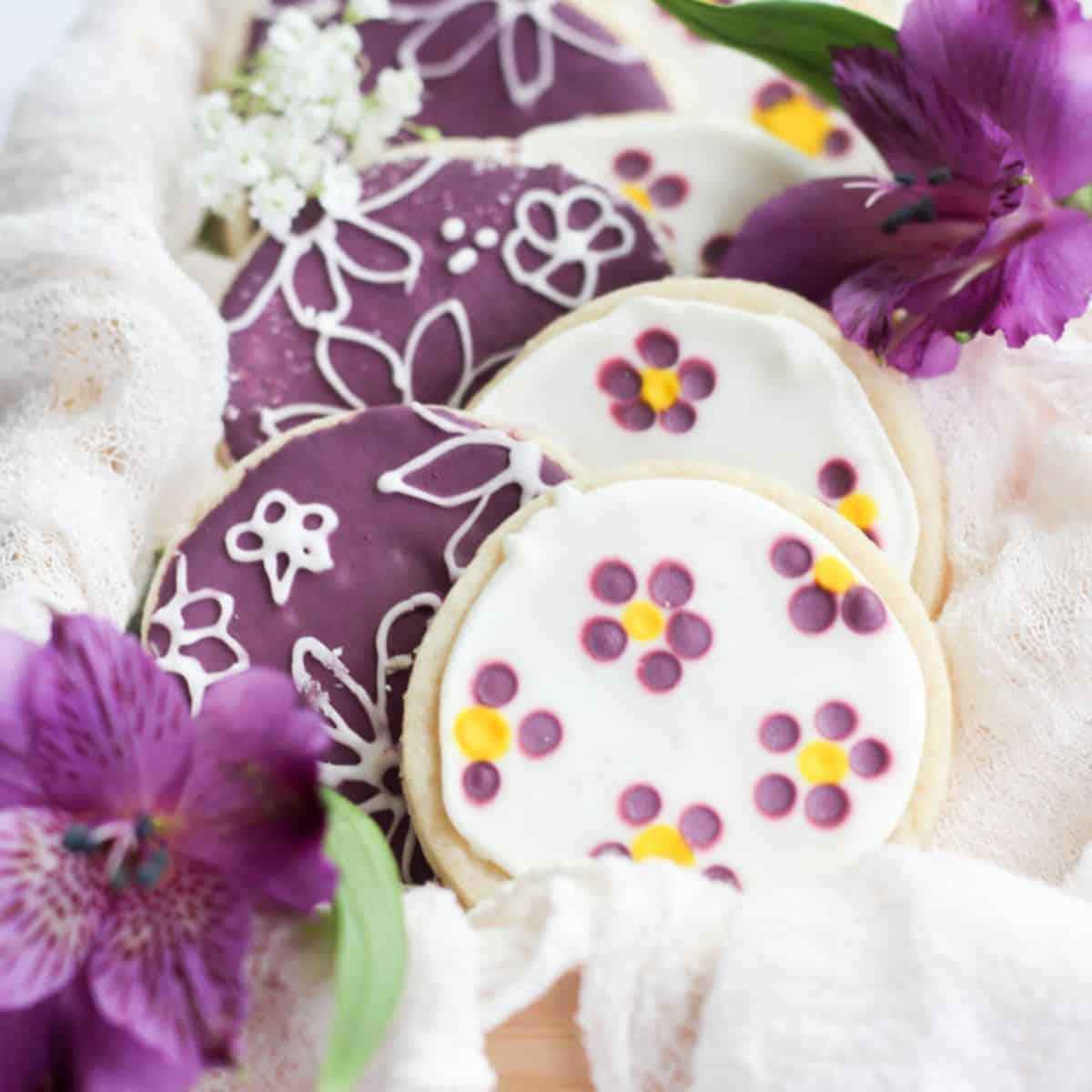 no spread sugar cookies decorated with flowers in a wood box.
