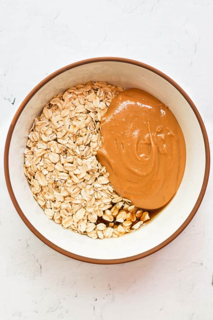 oats, peanut butter, and maple syrup in white bowl.
