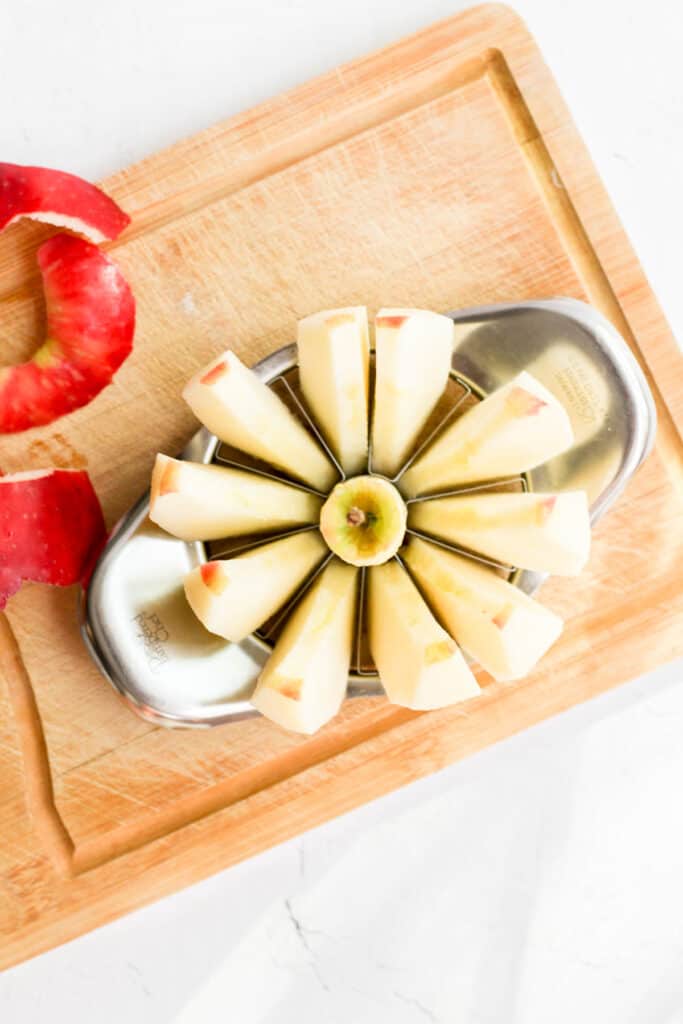 peeled apple on cutting board cut into slices.