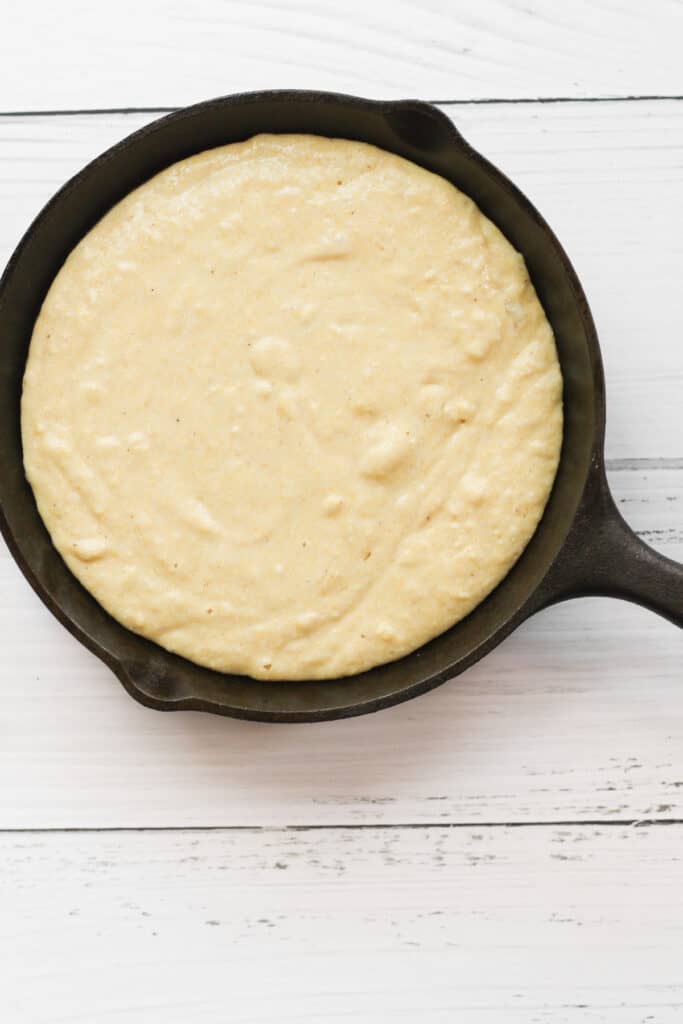dairy free cornbread batter in black cast iron pan.