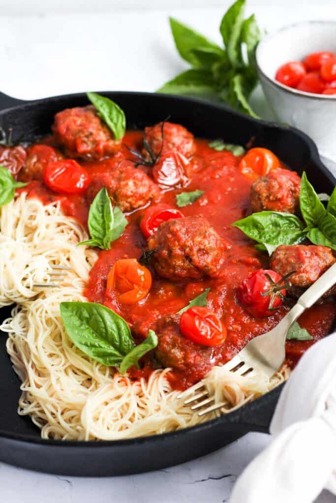 eggless meatballs in sauce with spaghetti and basil.
